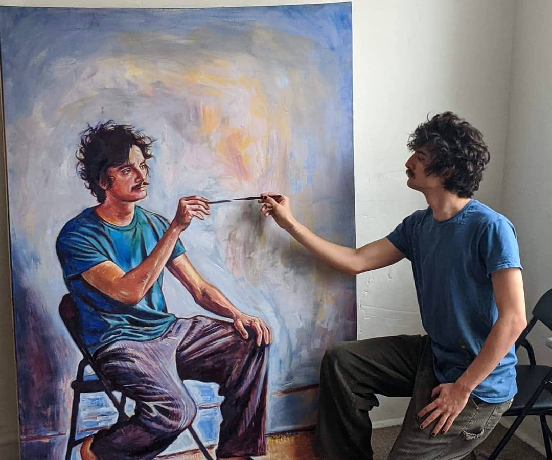 man paints a self-portrait