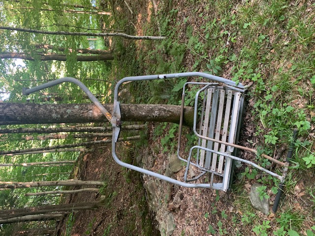 Detached ski lift chair on the forest floor