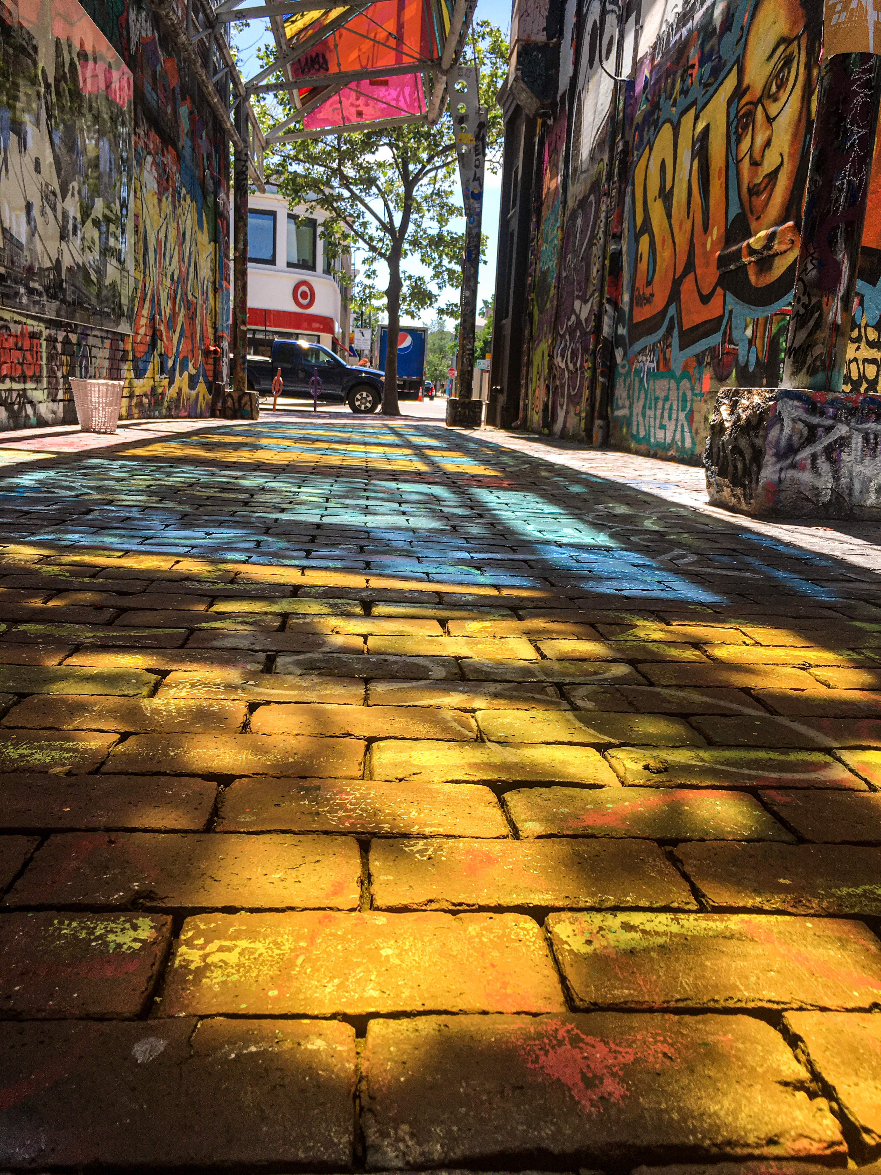 graffiti alley in Camrbidge, Massachusetts during the summer with the sun creating a kaleidoscope of colors on the floor