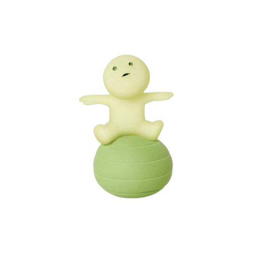 small green figure sitting on a ball