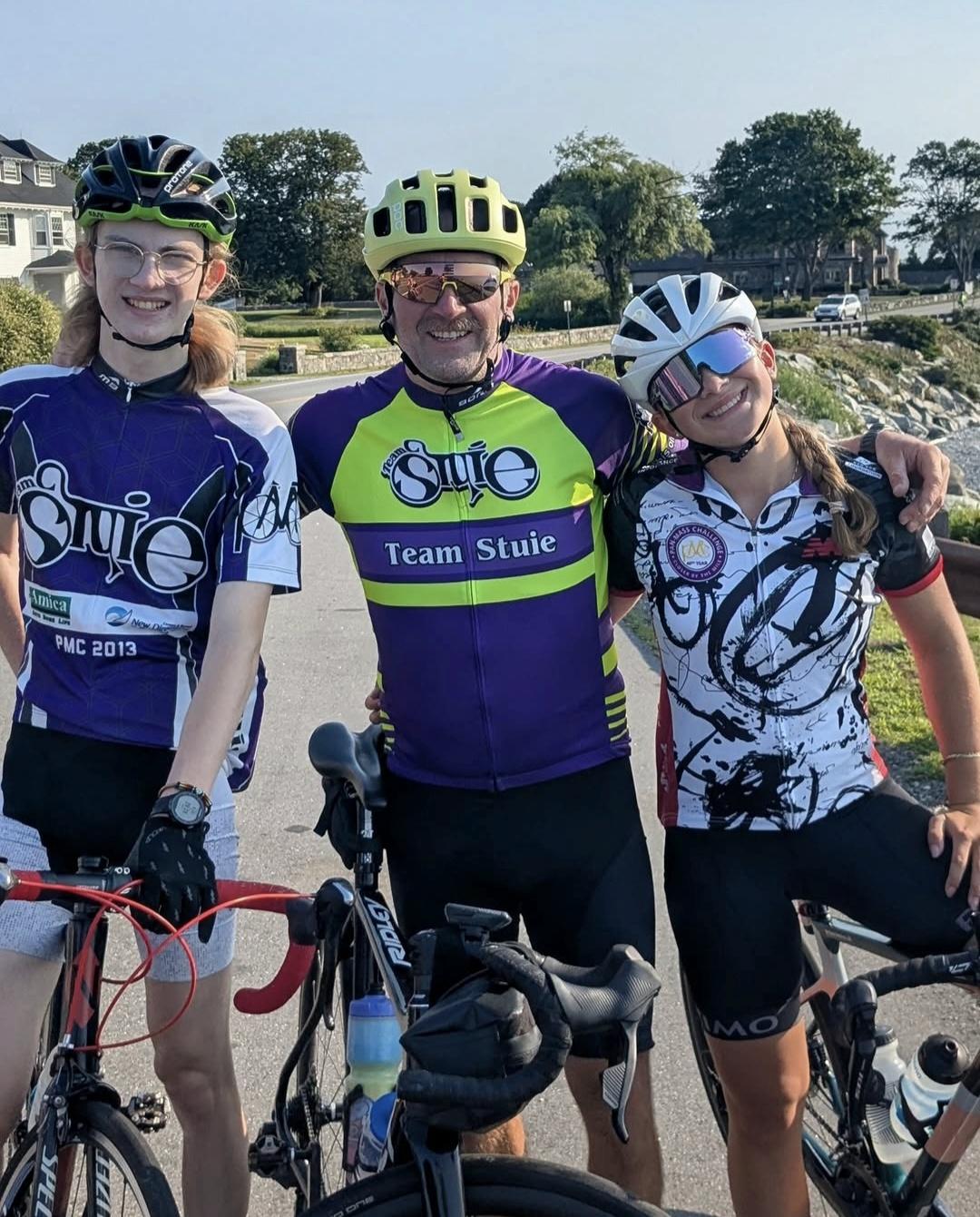 Picture of Nik and their Dad and sister on bikes